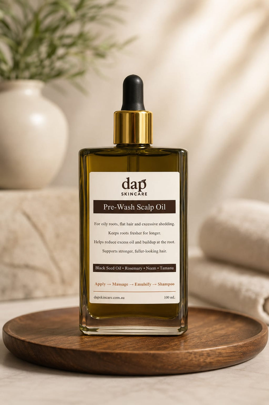 DAP skincare pre-wash scalp oil bottle on a wooden tray with a neutral background