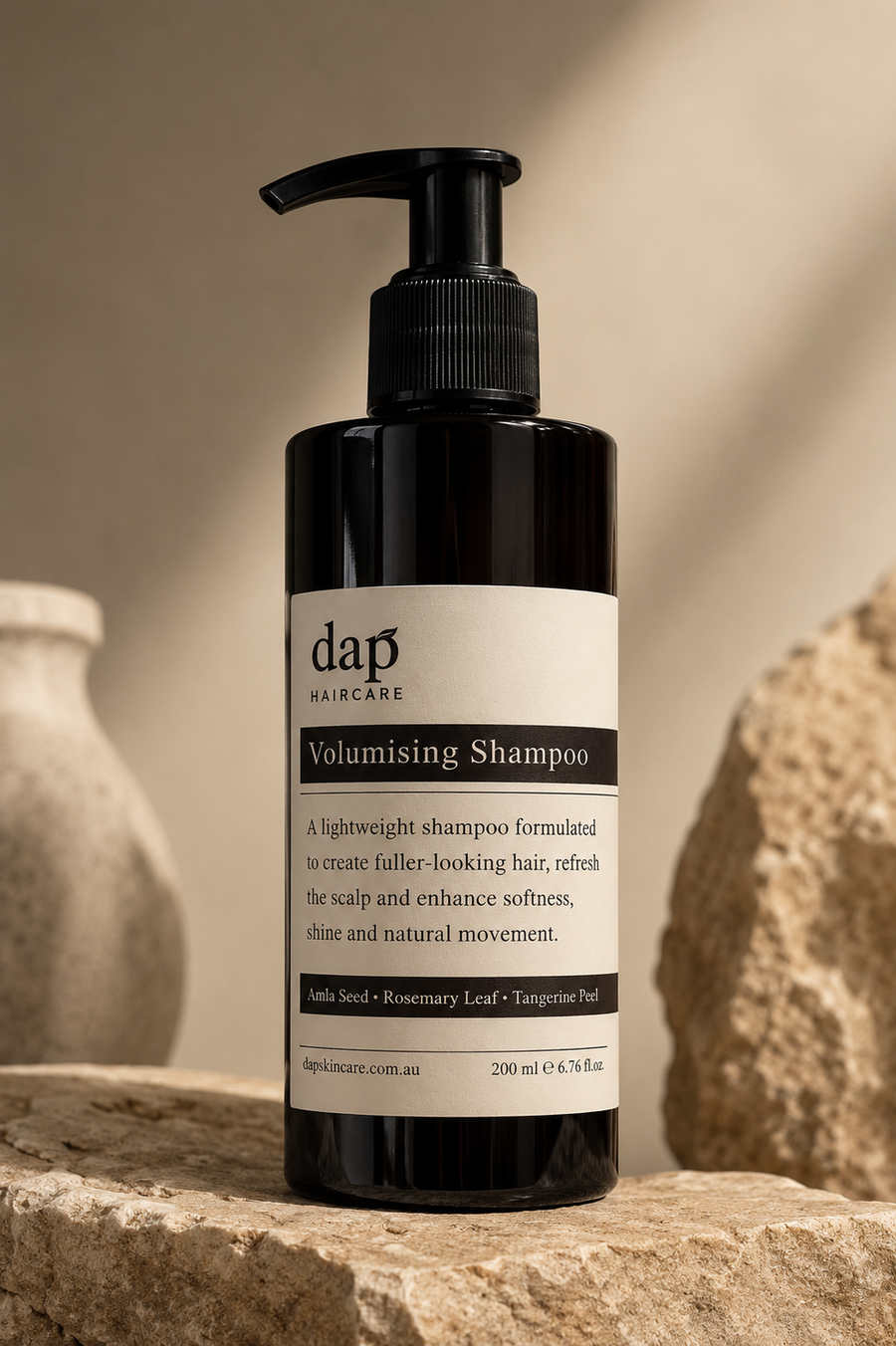 DAP Volumising Shampoo bottle on a stone surface with a neutral background