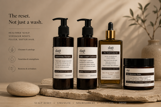 Set of DAP hair care products on a wooden surface with a neutral background