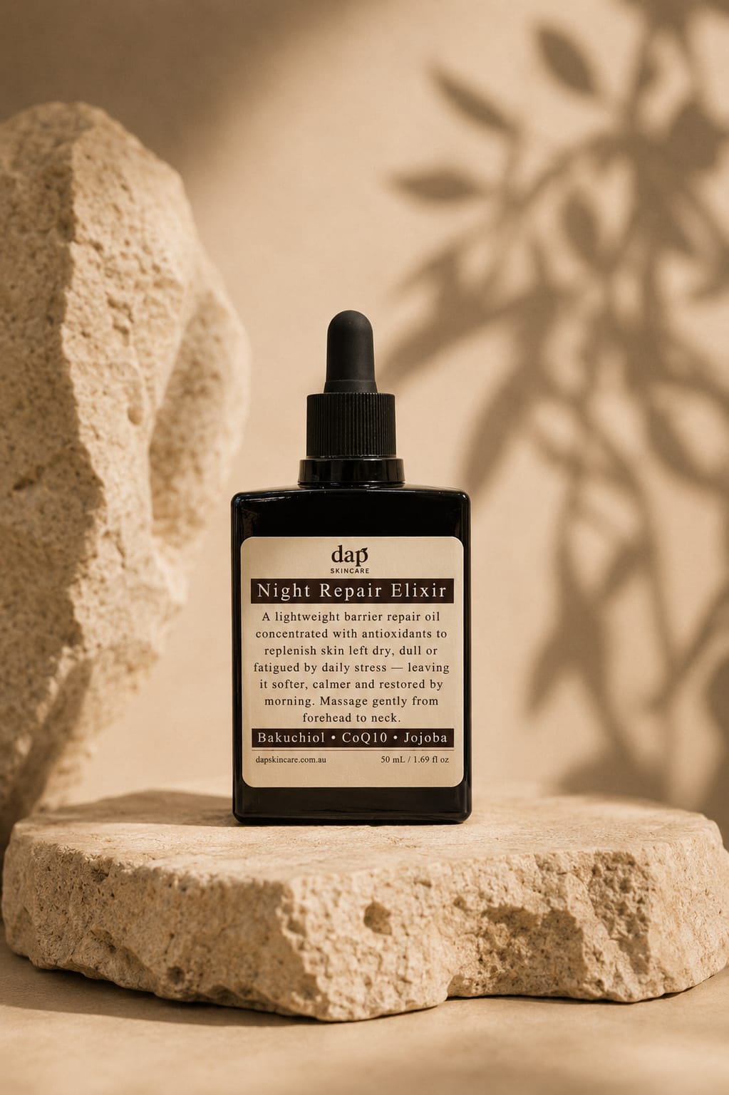 Bottle of Night Repair Elixir on a stone surface with a natural background