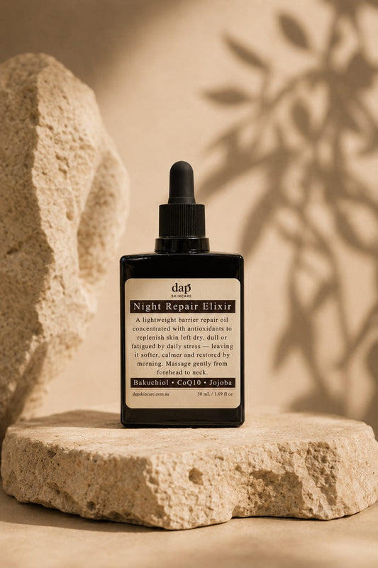 Bottle of Night Repair Elixir on a stone surface with a natural background